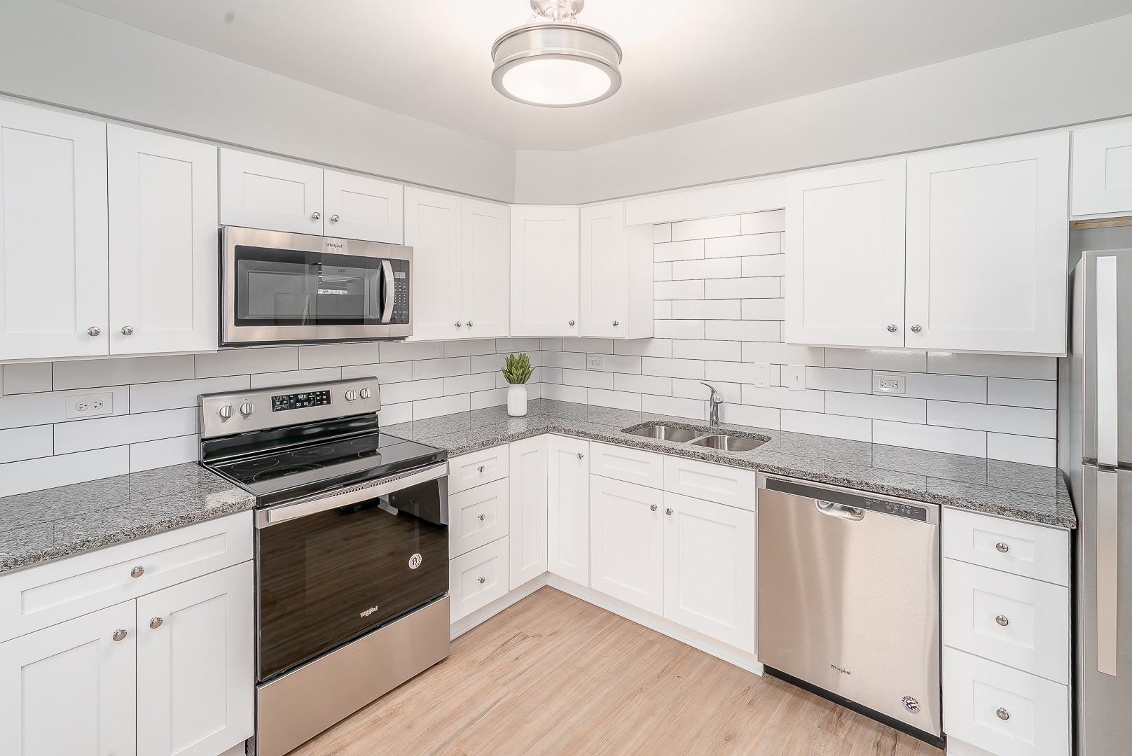 27 South Spring Avenue, Unit 2 La Grange, IL 60525 - Photo 9 of 13 a kitchen with granite countertop white cabinets white stainless steel appliances and a sink