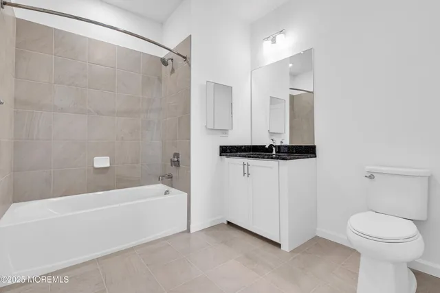 a bathroom with a granite countertop sink a toilet and shower