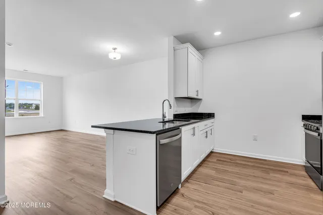 a kitchen with granite countertop a stove and a sink