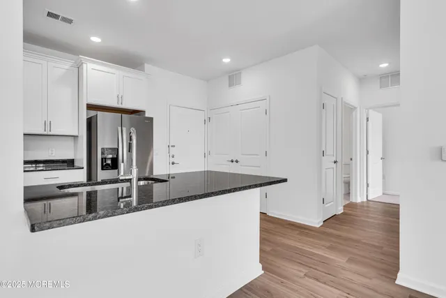 a kitchen with granite countertop a sink stove and refrigerator