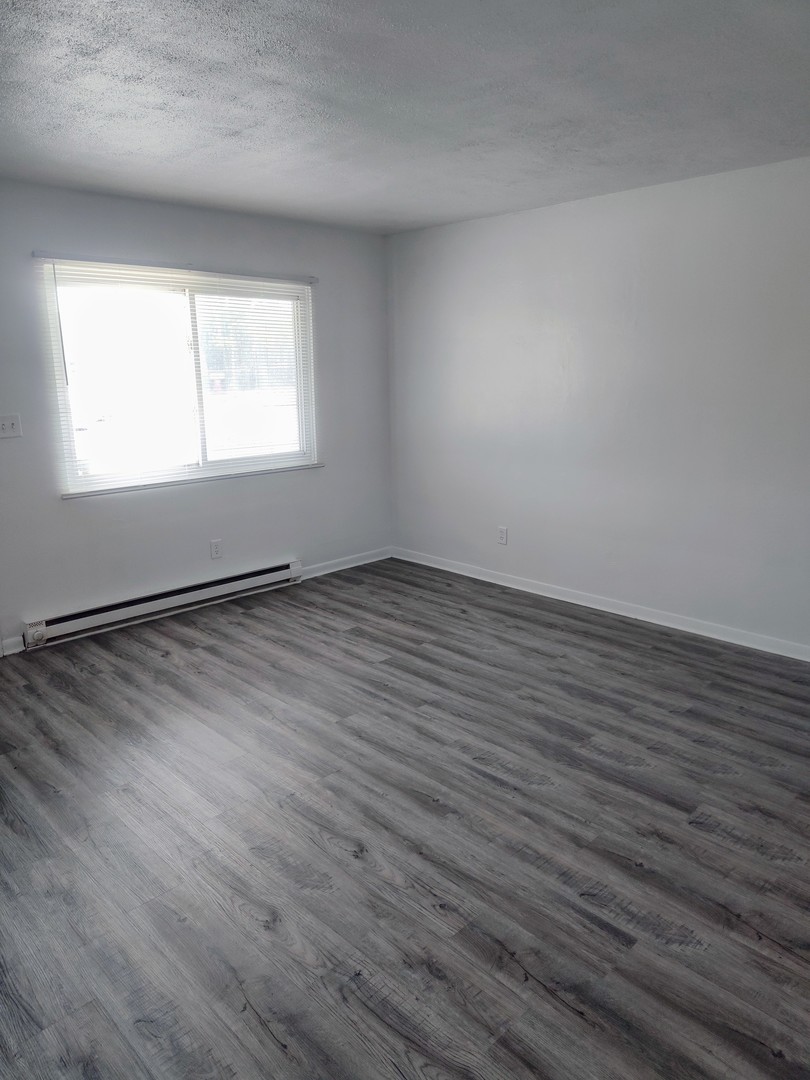 1039 Sheridan Road, Unit 1 Winthrop Harbor, IL 60096 - Photo 3 of 8 an empty room with wooden floor and windows