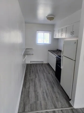 a kitchen with wooden floors and white appliances