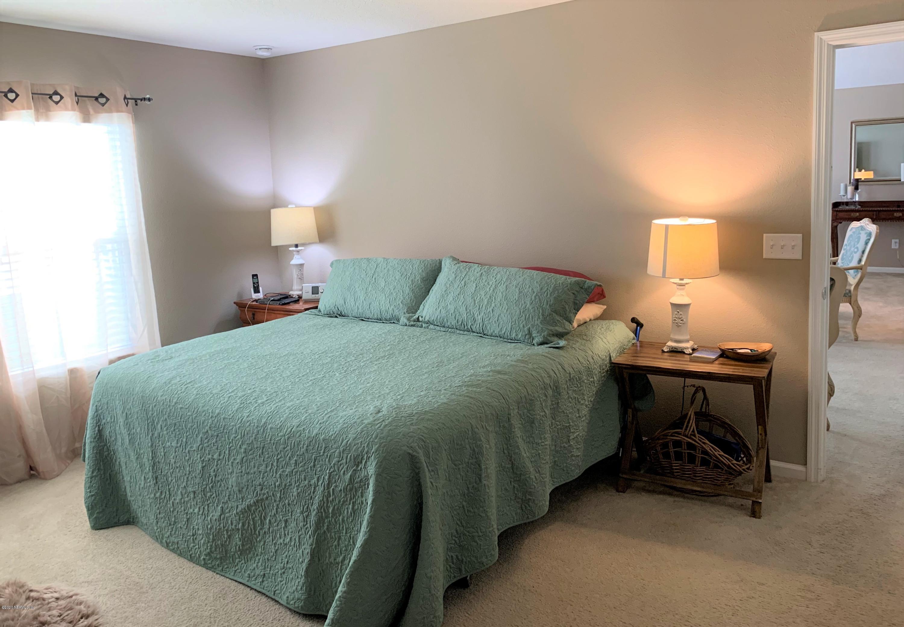 16007 Hutton Lane Jacksonville, FL 32218 - Photo 12 of 29 a bedroom with a bed and a lamp