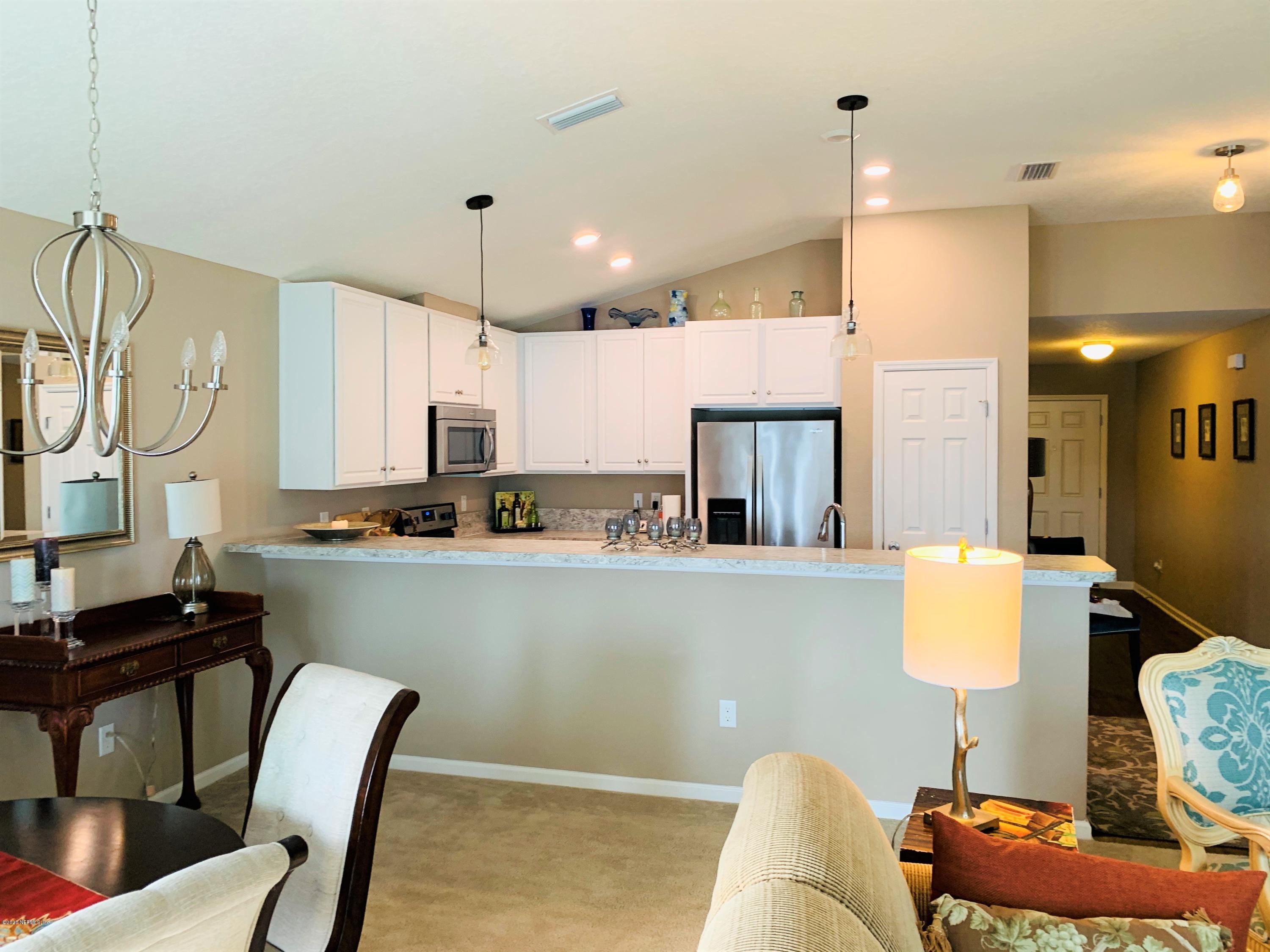 16007 Hutton Lane Jacksonville, FL 32218 - Photo 8 of 29 a kitchen with stainless steel appliances kitchen island granite countertop a table chairs and a refrigerator