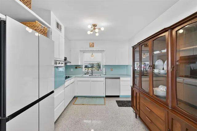 a kitchen with white cabinets and refrigerator