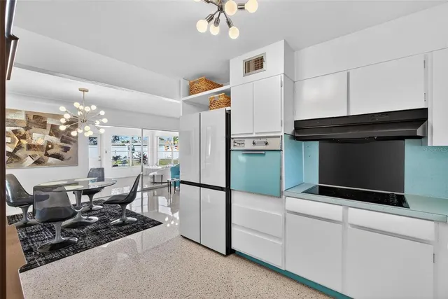 a kitchen with stainless steel appliances kitchen island granite countertop a stove a microwave and a dining table