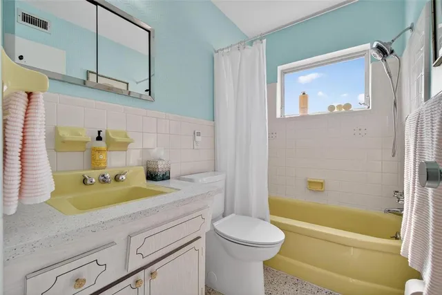 a bathroom with a granite countertop sink a toilet and bathtub