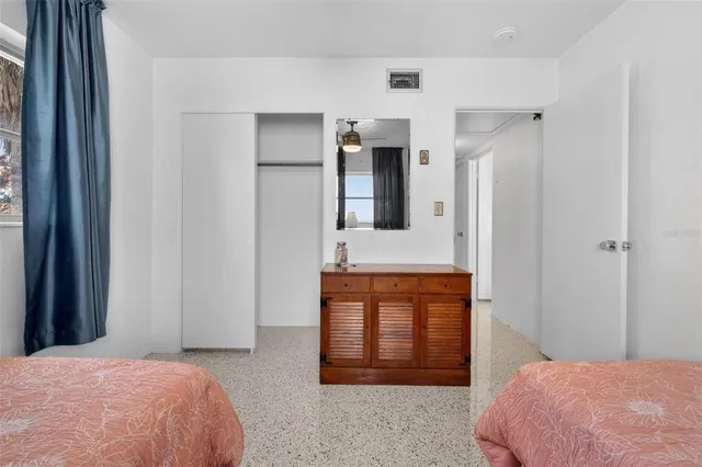 a bedroom with a bed dresser and mirror