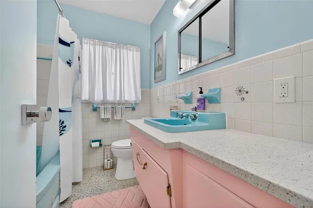 a bathroom with a sink a toilet and shower curtain