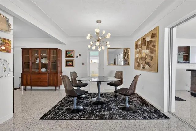 a dining room with wooden floor and large windows