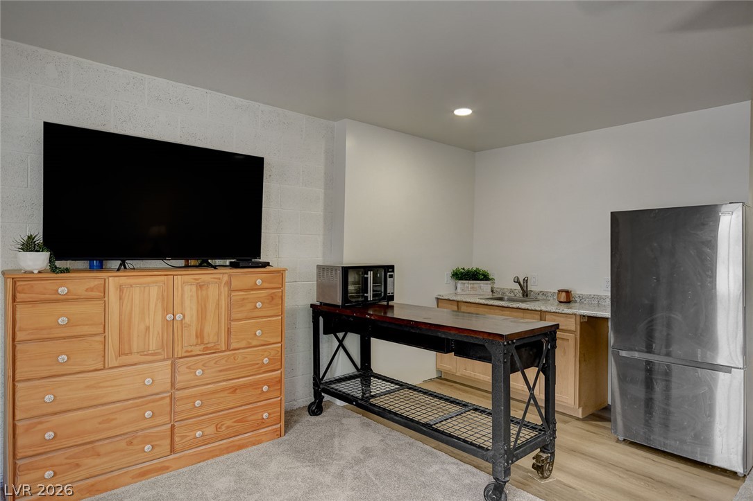 1920 Bowman Road Logandale, NV 89021 - Photo 53 of 68 Functional basement kitchenette features durable wood-look flooring alongside a cozy carpeted area.