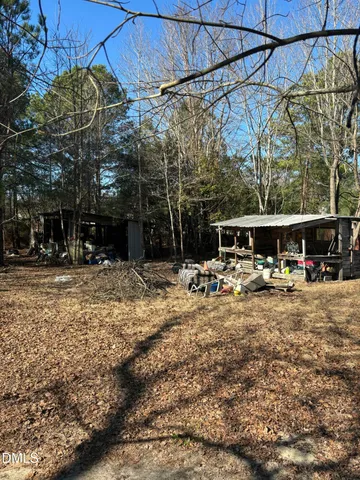 a view of a backyard with table and chairs under an umbrella