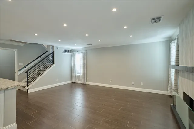 an empty room with wooden floor and staircase