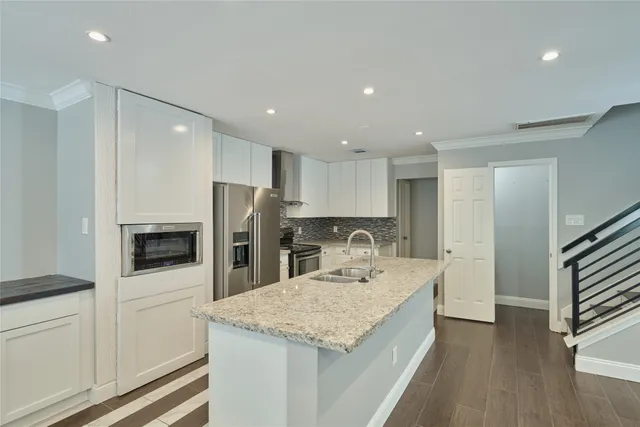 a kitchen with a sink a counter space stainless steel appliances and cabinets