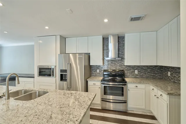 a kitchen with granite countertop a refrigerator stove and sink