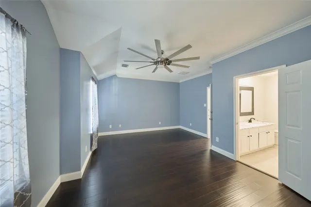 an empty room with wooden floor and a ceiling fan
