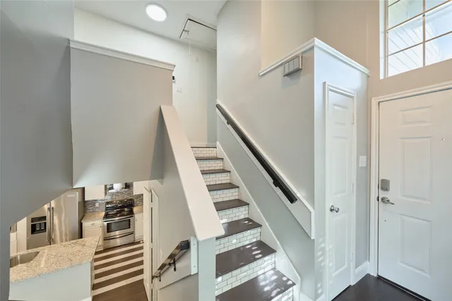 a view of a livingroom with wooden floor and stairs