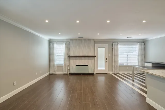 a view of empty room with wooden floor and window