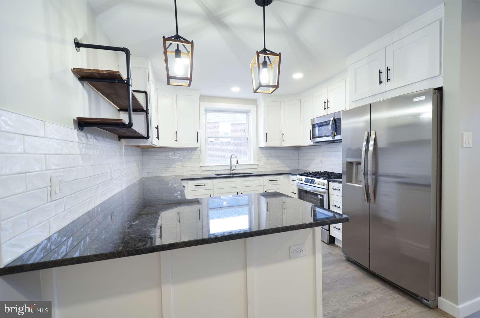 8213 Colfax Street Philadelphia, PA 19136 - Photo 5 of 25 a kitchen with stainless steel appliances granite countertop a sink a stove a refrigerator and island