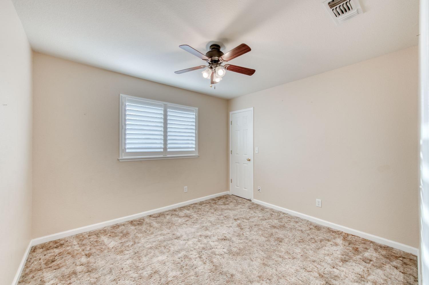 8062 Monreal Drive Sanger, CA 93657 - Photo 13 of 24 an empty room with windows and fan