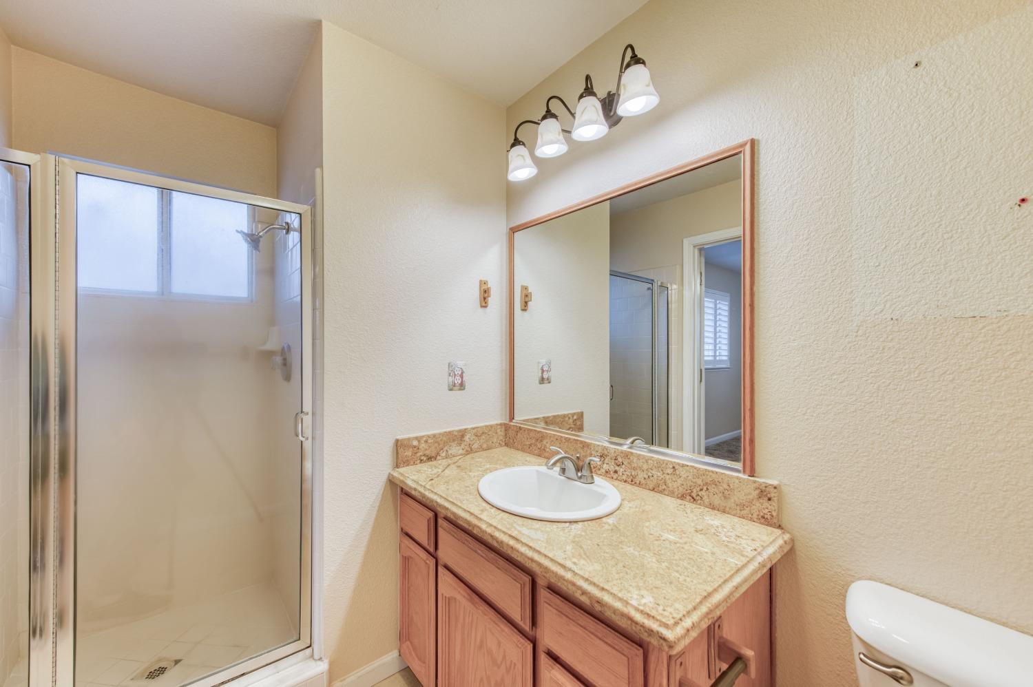 8062 Monreal Drive Sanger, CA 93657 - Photo 16 of 24 a bathroom with a granite countertop sink and a mirror