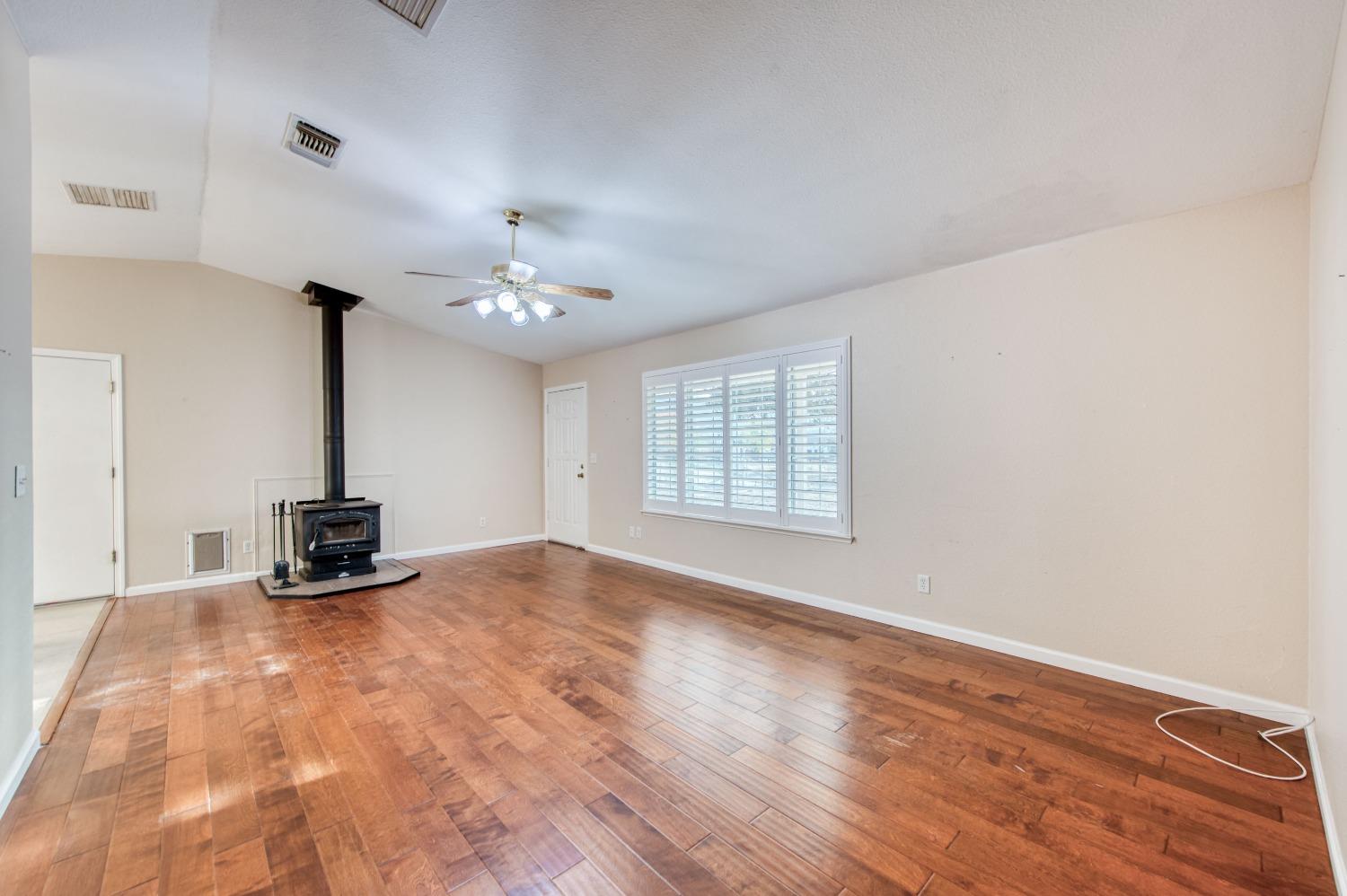 8062 Monreal Drive Sanger, CA 93657 - Photo 5 of 24 a kitchen with kitchen island a stove and a wooden floor