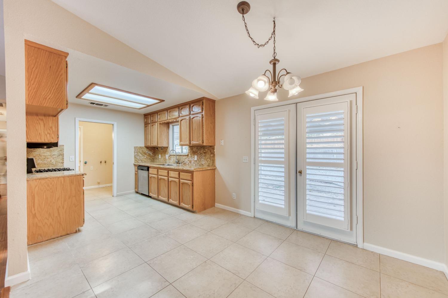 8062 Monreal Drive Sanger, CA 93657 - Photo 7 of 24 a kitchen with stainless steel appliances granite countertop a sink a stove cabinets and a dining table