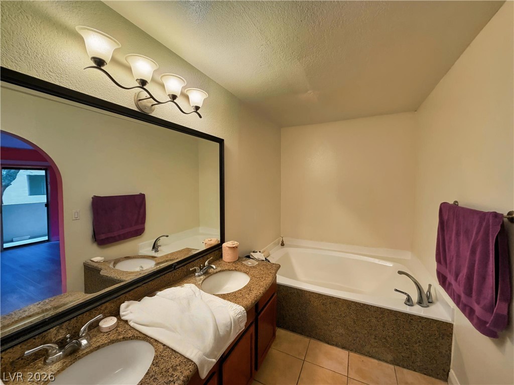 1852 North Decatur Boulevard, Unit 101 Las Vegas, NV 89108 - Photo 41 of 45 Granite counters and a deep soaking tub highlight this relaxing bathroom space.