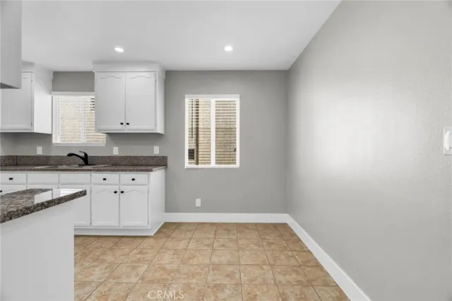 a kitchen with granite countertop a sink a stove a microwave and cabinets