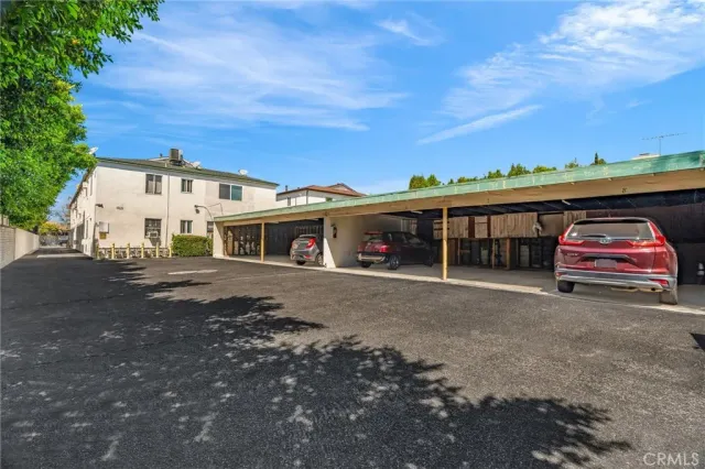 a front view of a house with parking space and a car parked in it