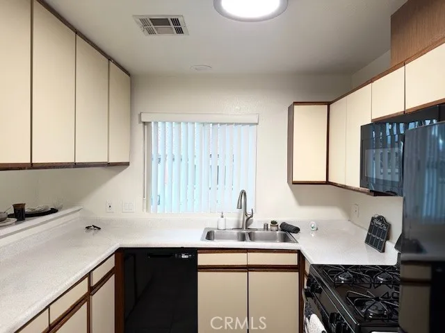 a kitchen with a sink a stove cabinets and a window