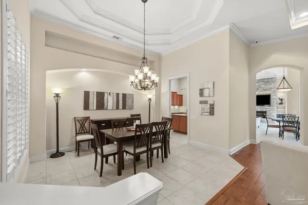 a dining room with furniture a chandelier and wooden floor