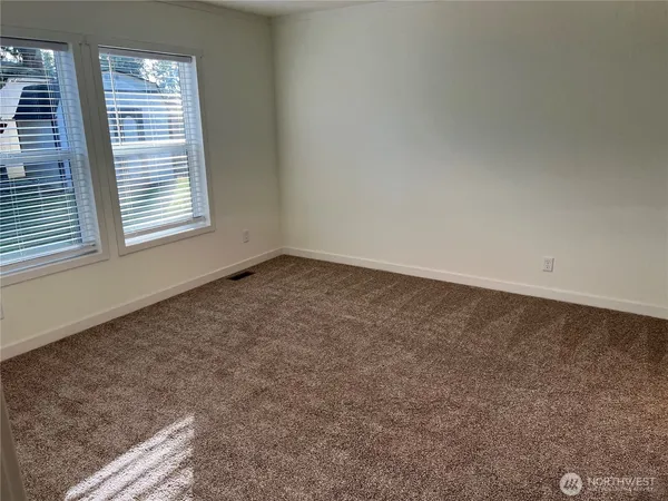an empty room with a fireplace and wooden floor