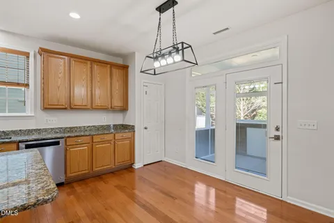 a large kitchen with granite countertop a large counter top stainless steel appliances and cabinets