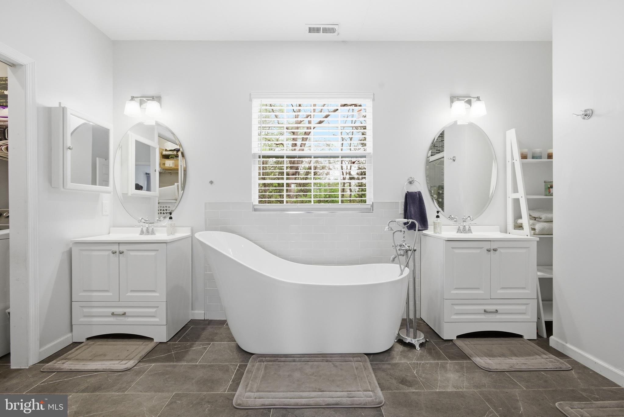 8664 Pohick Forest Court Springfield, VA 22153 - Photo 22 of 41 a spacious bathroom with a bathtub sink and mirror