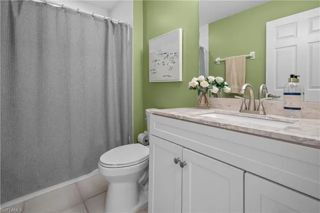 a bathroom with a granite countertop sink toilet and mirror