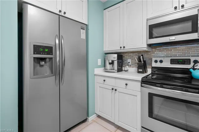 a kitchen with stainless steel appliances white cabinets and a stove