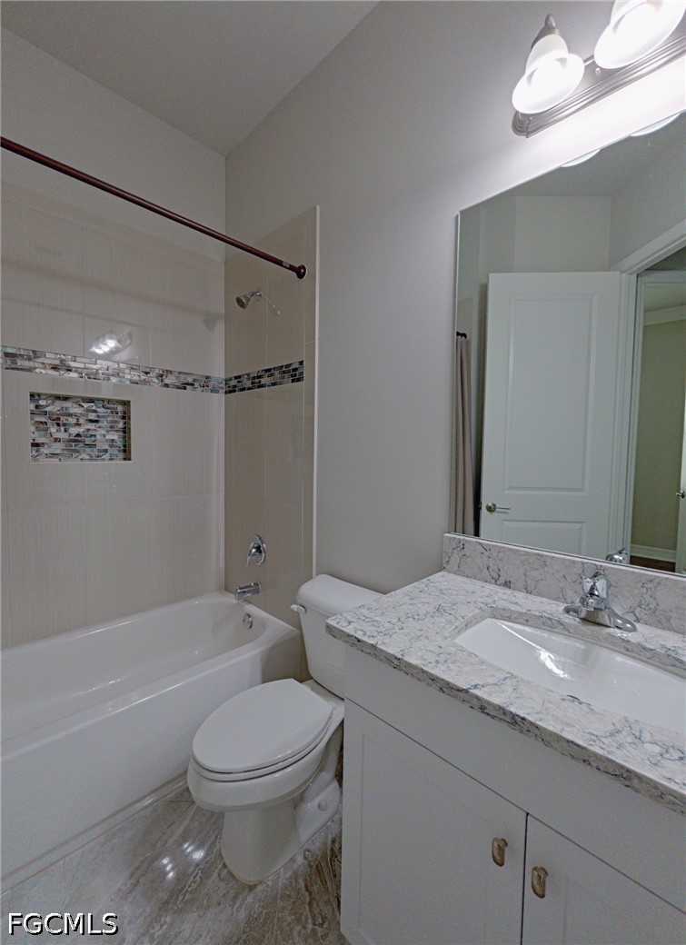 4129 Amelia Way Naples, FL 34119 - Photo 17 of 23 a bathroom with a granite countertop sink toilet vanity mirror bathtub and shower