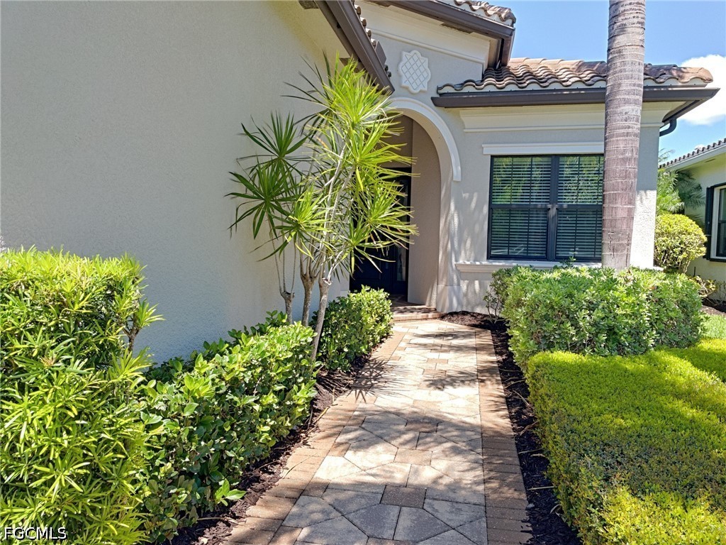 4129 Amelia Way Naples, FL 34119 - Photo 2 of 23 a front view of a house with a garden