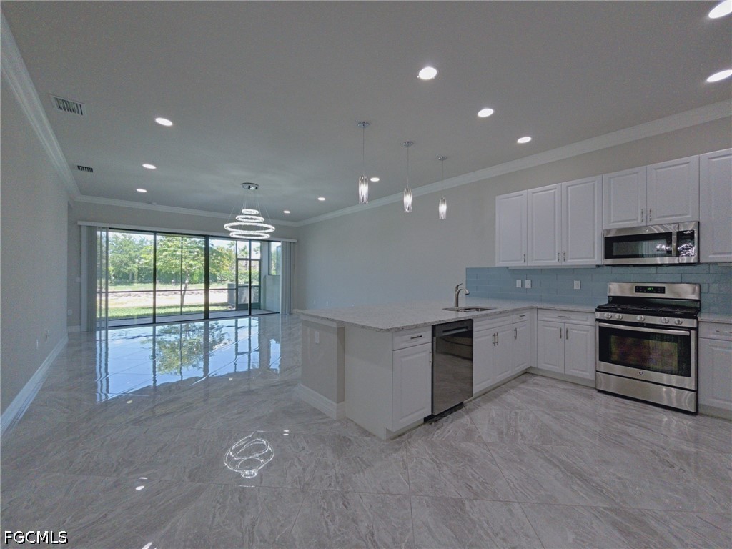 4129 Amelia Way Naples, FL 34119 - Photo 6 of 23 a large kitchen with stainless steel appliances granite countertop a stove a sink and a microwave