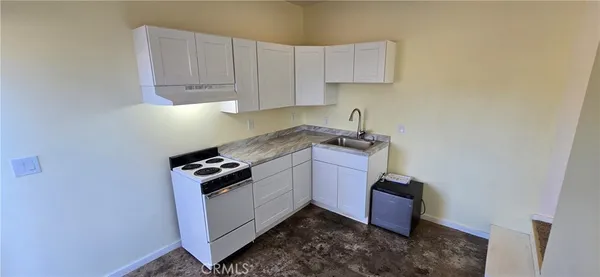 a kitchen with granite countertop white cabinets and stainless steel appliances