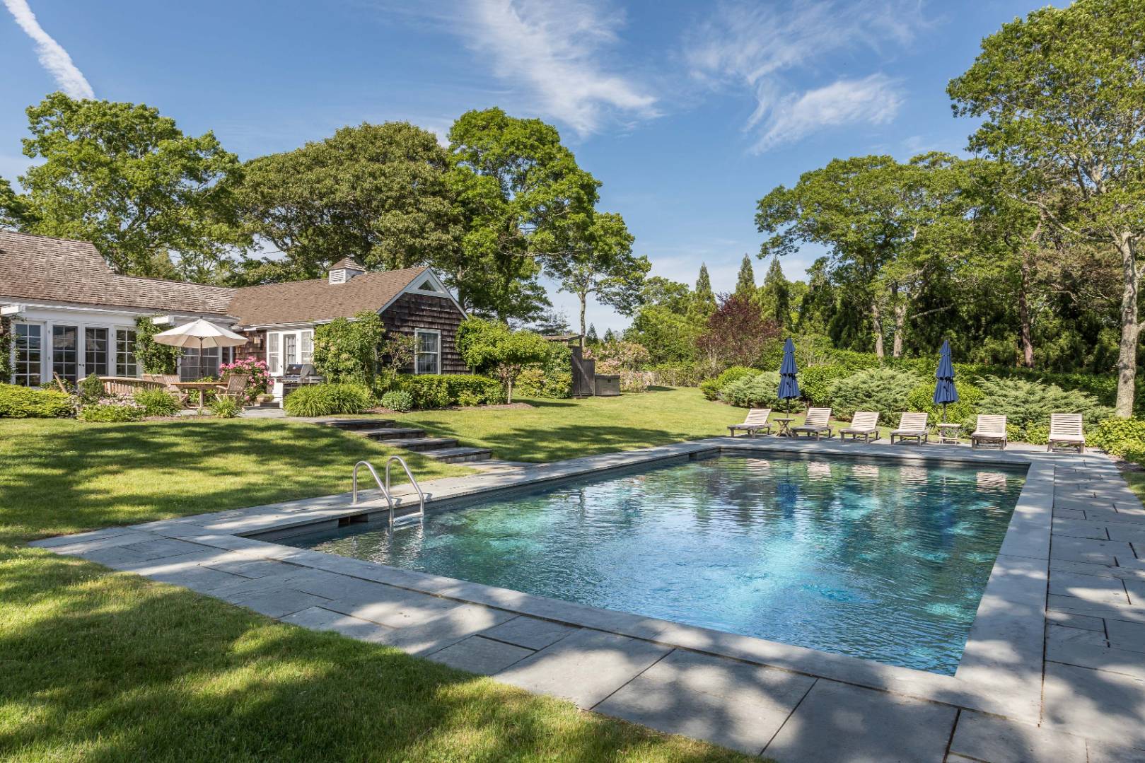 253 Georgica Road East Hampton, NY 11937 - Photo 16 of 19 a view of swimming pool with outdoor seating and trees in the background