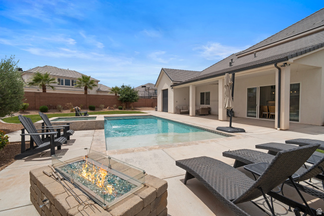2278 Tawny Ridge Circle St. George, UT 84790 - Photo 52 of 61 Private backyard oasis featuring a rectangular swimming pool with integrated spa, a paved patio, and a built-in stone fire pit.