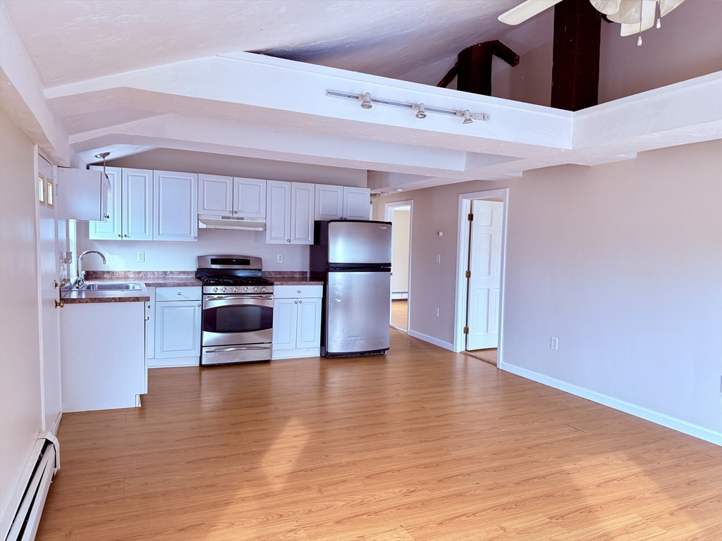a kitchen with stainless steel appliances granite countertop a refrigerator and a stove top oven