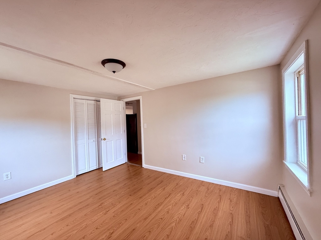 16 Cox Court, Unit 3 Beverly, MA 01915 - Photo 4 of 14 a view of an empty room with wooden floor and a window
