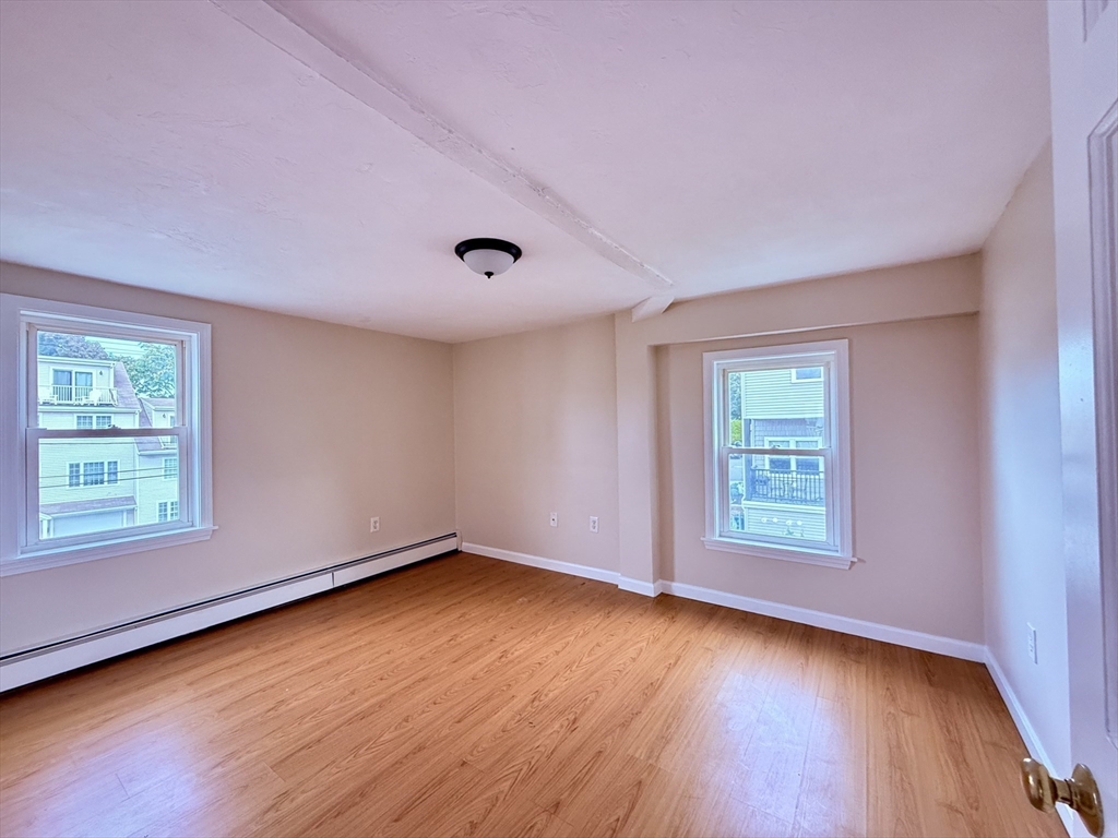 16 Cox Court, Unit 3 Beverly, MA 01915 - Photo 9 of 14 an empty room with wooden floor and windows