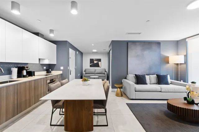 a living room with a couch and a dining table with wooden floor