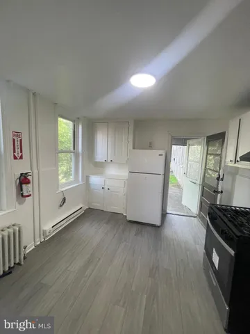 a kitchen with cabinets and wooden floor