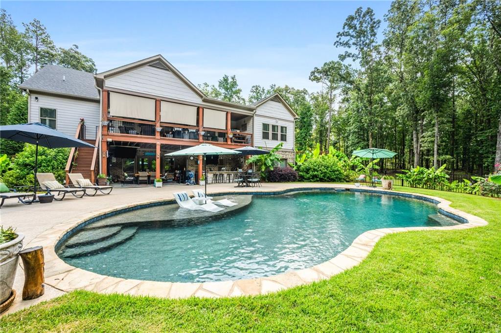 a view of a house with swimming pool and sitting area