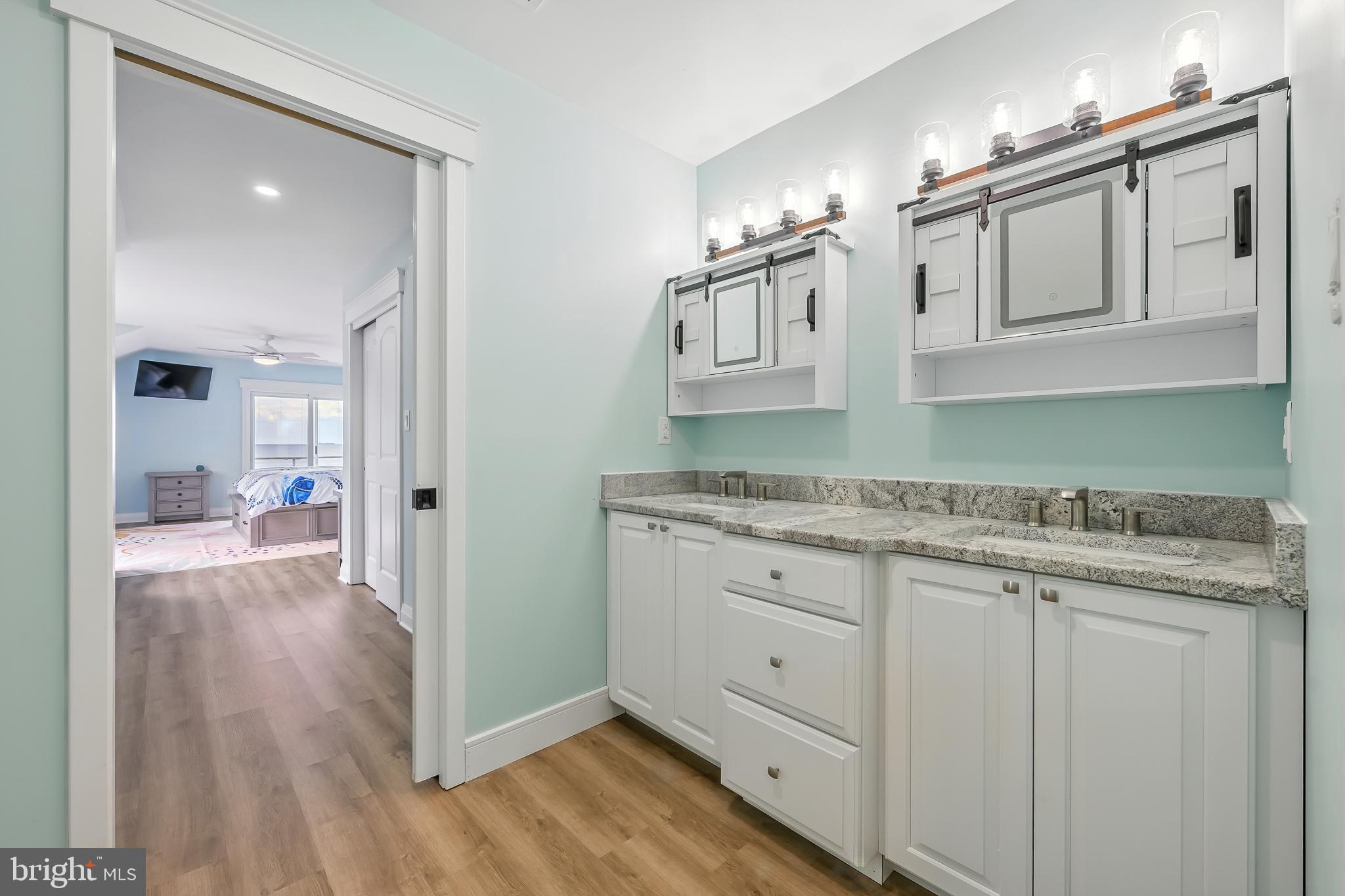 549 Bay Avenue Milford, DE 19963 - Photo 35 of 60 a bathroom with granite countertop a sink and a wooden floor